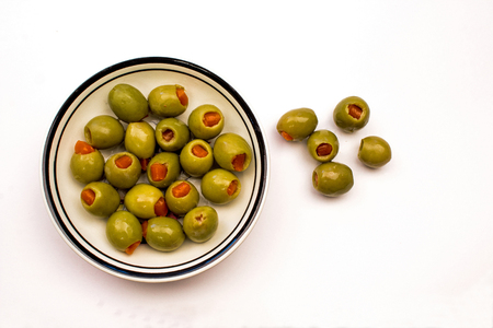 Closeup of a Bowl of Green Stuffed Olives on a white backgroundの写真素材