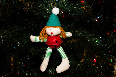 Handmade Elf Ornament with a Red Jingle Bell on a Christmas Treeの写真素材