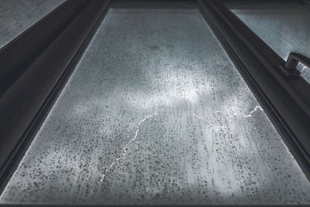 window with rain and lightningの写真素材