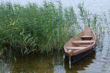 wooden boat over the riverside of lakeの写真素材