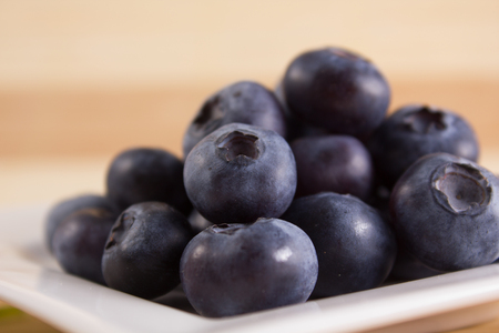 bilberries close on a white square-shaped plate の写真素材