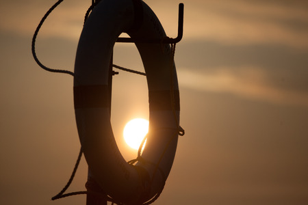 rescue ring close in a sunrise, orange clouds in the back の写真素材