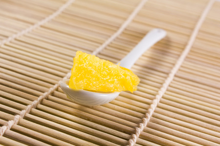 a white spoon with a piece of a pineappleの写真素材