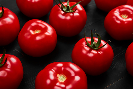 Tomato on a black background with realistic reflection and water drops. Fresh tomatoesの写真素材