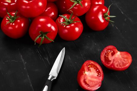 Tomato on a black background with realistic reflection and water drops. Fresh tomatoesの写真素材