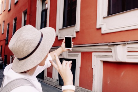 Happy young female traveler taking selfie on street. Travel conceptの写真素材