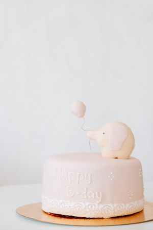 Delicious pink cake with elephant on white background. Birthday concept.の写真素材