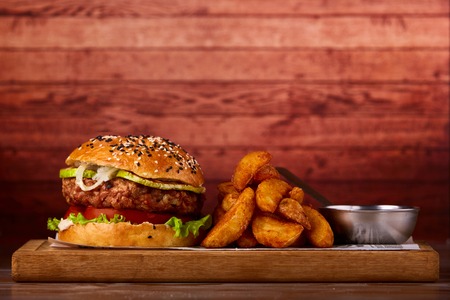 Hamburger served on wooden planks. Homemade hamburger with lettuce and cheese.の写真素材
