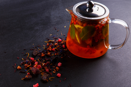 Fruit tea with slice of lemon. Mixture herbal floral fruit tea with petals, dry berries and fruitsの写真素材