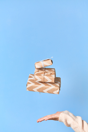 Woman's hands trying to catch gift box. Christmas or new year decorated gift boxの写真素材