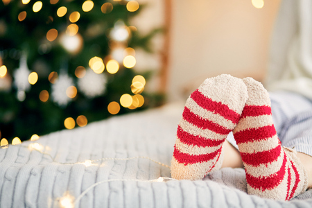 Feet in wool socks at fireplace. Christmas holidayの写真素材