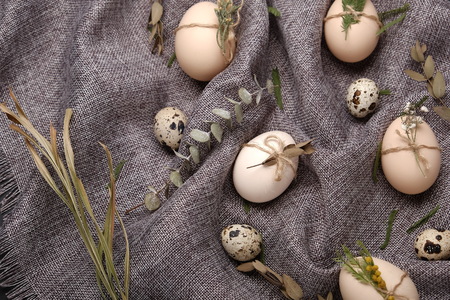 Chicken and quails eggs with decorative elements on black background.