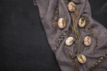 Chicken and quails eggs with decorative elements on black background.