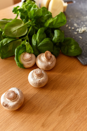Fresh champignon mushrooms with vegetables on dark tableの写真素材