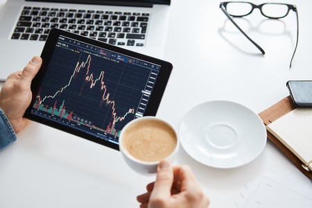 Investor watching the change of stock market on tabletの写真素材