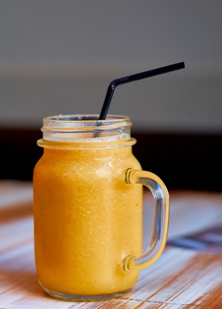 Healthy yellow smoothie with mango pineapple banana in mason jarsの写真素材