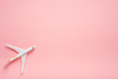 Top view of an airplane on trendy pink background.  Bright summer color. Travel conceptの写真素材