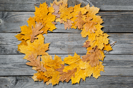 Frame of colorful autumn maple leaves closeup on wooden backgroundの写真素材