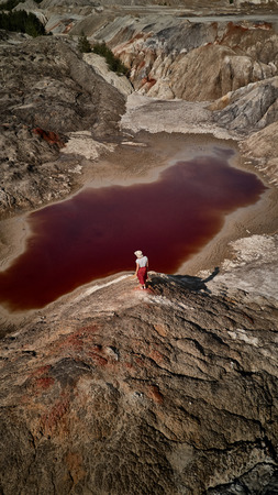 Woman with hat on background fantastic earth with red river at aerial view. Fantastic view. Martian landscapeの写真素材