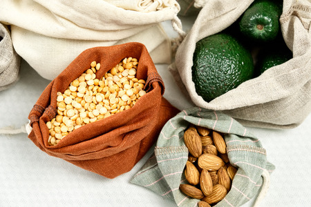 Zero Waste Food Storage Eco Bag Top View. Natural Organic Sack for Grocery Keeping Fresh Top Down Photo Isolated on White Background. Vegetables in Linen Pack. Reusable Green Lifestyle Conceptの写真素材