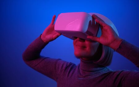 Young Woman Playing on Vr Glasses Touching Air During Virtual Reality Experience Isolated on Blue...