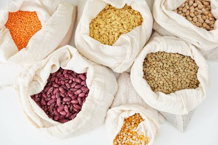 Vermicelli Macaroni Peas Beans Chickpea Lentils Agricultural Cereal Types in Textile Fabric Bag Set Isolated on White Background Flat Lay. Collection of Healthy Vegetarian Food in Pouchの写真素材