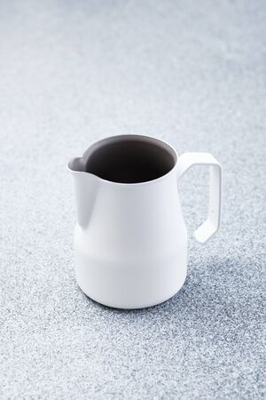 Metallic Pinscher Barista Tool for Pouring Milk in Coffee Isolated on White Background Copy Space. Equipment for Make Preparation Breakfast Morning Hot Aroma Drink Cappuccino Latteの写真素材