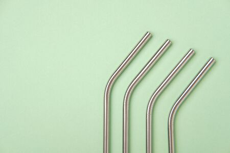 Steel Aluminum and White Plastic Drinking Straw in Glass and Scattered on Table. Stainless Reusable Bar Equipment for Drink Cocktails, Water or Lemonadeの写真素材