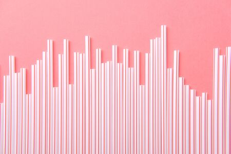 Plastic Drinking Straw Isolated on Pink Background Flat Lay Top View. Battered Bitten and Stainless Reusable Bar Element Tube for Drink Cocktails, Water and Lemonadeの写真素材