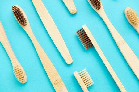 Wooden Toothbrush Isolated on Blue Background Copy Space Flat Lay. Tooth Brushes Scattered on Table. Collection of Elegant Ecological Clear Healthcare Bath Accessory for Clean Teethの写真素材