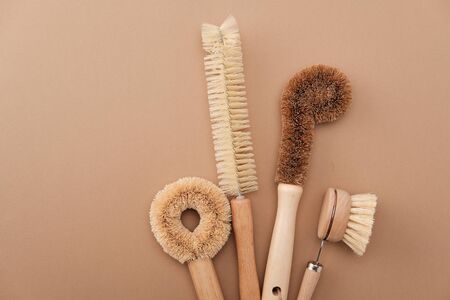 Kitchen Dish Brushes in Brown Ceramic Cup Isolated on Beige Background Side View Copy Space. Little...