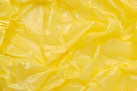 Close up Texture of a Yellow Plastic garbage Bag. Yellow Polyethylene Film. Texture of cellophane