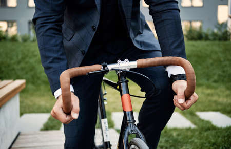 Man in elegant suit riding bicycle. Man wearing office clothes a bicycle in street going to officeの写真素材