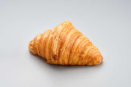 Fresh baked croissant. Warm fresh buttery croissant on a grey backgroundon. French croissant enjoyed world wide. Macro photography.の写真素材