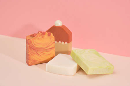 Collection of organic handmade soaps with cinnamon, cocoa, lime and berries on a pink background. Spa at your home. Products without plastic packaging. Side view.の写真素材