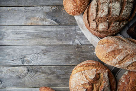 Assorted homemade gluten-free and yeast-free bread on grey wooden background. View from above.
