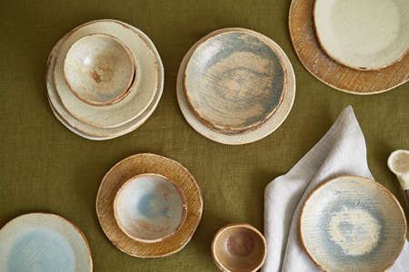 Modern dining table setting. Only natural materials - earthenware, linen textiles, dried flowers....