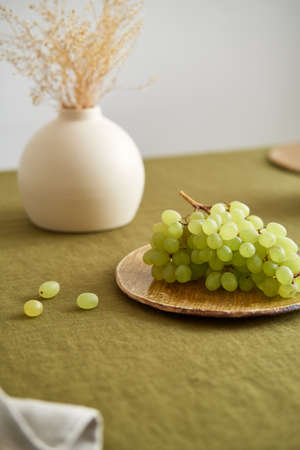 Modern dining table setting. Only natural materials - earthenware, linen textiles, dried flowers. Side view.の写真素材