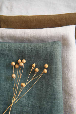 Collection of natural linen kitchen towels stacked neatly in a horizontally. Natural, soft and stylish kitchen textiles. View from above.の写真素材