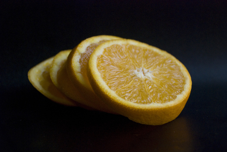 Fresh orange slices in a black backgroundの写真素材