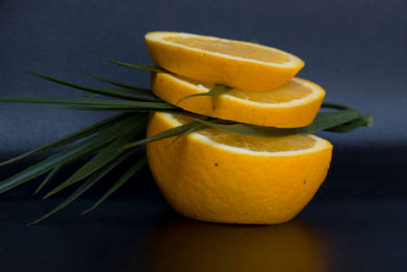 fresh orange slices and green leaves in a dark backgroundの写真素材