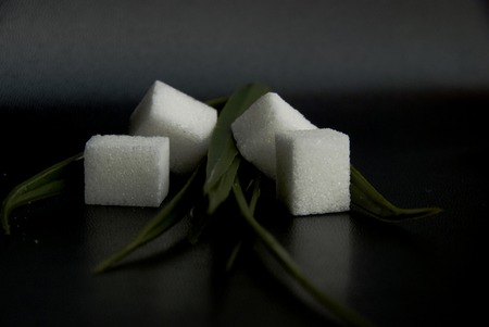 White sugar pieces with herbs in a black backgroundの写真素材