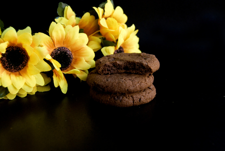 Yellow autumn flowers set in a black background with cookiesの写真素材