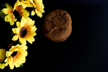 Yellow autumn flowers set in a black background with cookiesの写真素材