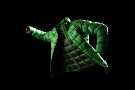 Green down jacket in movement posture with ghost effect with black backgroundの写真素材