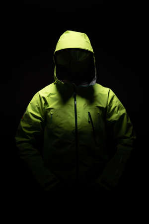 Green waterproof jacket  in static position with ghost effect and black background