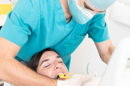Dentist preparing to make an x-ray radiography to a patientの写真素材
