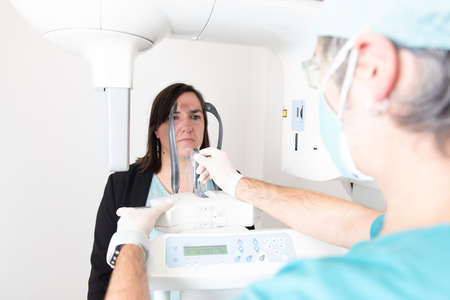 A patient about to have a scan in a panoramic dental x-ray machine.の写真素材