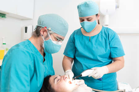 Dentist and an assistant nurse treating a patient.の写真素材