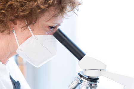 Closeup frame with copy space of a female scientist doctor analyzing samples in a microscope with a...